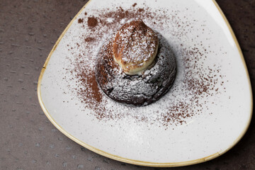 Chocolate cake with white powder on a white plate. dessert close-up, top view