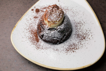 Chocolate cake with white powder on a white plate. dessert close-up, top view