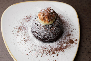 Chocolate cake with white powder on a white plate. dessert close-up, top view