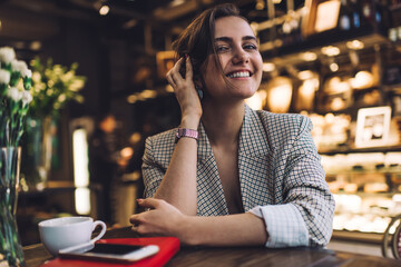 Portrait of cheerful hipster girl 20 years old smiling at camera during pastime posing in coffee...