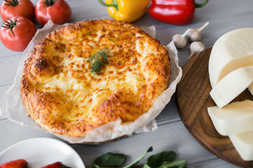 Georgian pita close-up. vegetables and fruits around. Gray background
