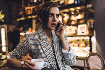 Young woman talking on smartphone in cafe