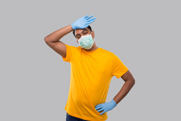 Fototapeta premium Indian Man Tired Sign Wearing Medical Mask and Gloves. Man WIping Sweat Isolated