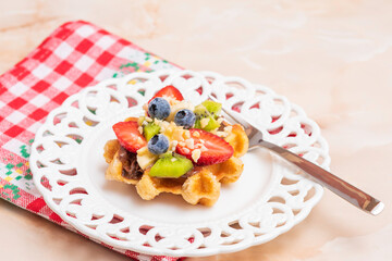 Belgian waffle with fruit and chocolate, on red and white napkin, with space for text