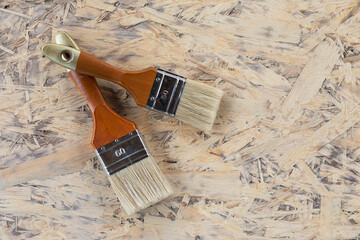 two brushes are prepared for repair and painting, lying on wooden plate