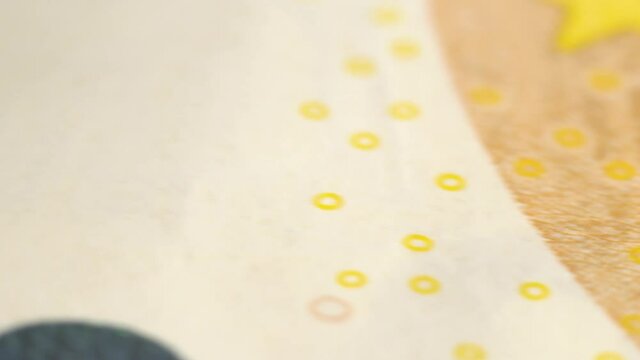 Counterfeiter or investor checks paper money in ultraviolet light. Extreme close-up view of a bank note under a microscope . Euro banknote under a magnifying glass.