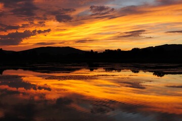 Obraz premium Lake, golden light at dusk. With reflection on the water surface. Beauty orange colored clouds . Dubnica, Slovakia.