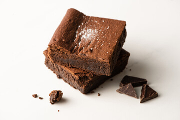 delicious brownie pieces with chocolate on white background
