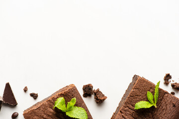 top view of delicious brownie pieces with mint and chocolate on white background