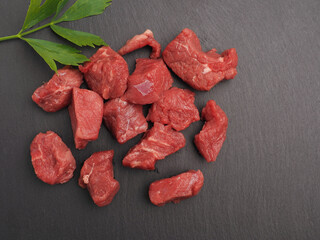 Raw organic beef on a slate plate with space for text