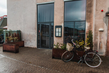 Fototapeta na wymiar Bicycle near flowerpots and facade of building in Copenhagen, Denmark