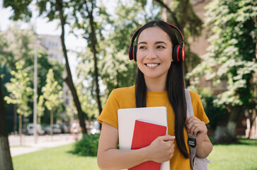 Smiling asian student walking to university. Back to school, education concept. Portrait of happy...