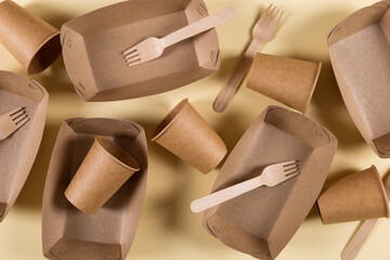 Paper eco-friendly utensils, without contamination, for reprocessing, brown on a yellow background.