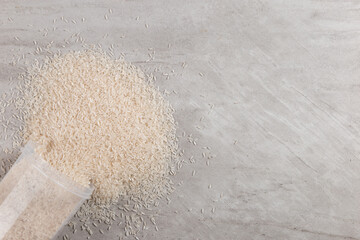 A jar of rice is scattered on a stone table, a blank, a place for text. Copy space.