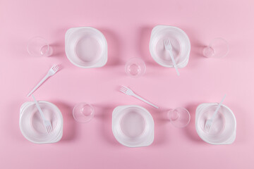 Fototapeta na wymiar Plastic utensils on a pink background. Not environmental, pollution.