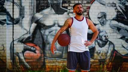 Obraz na płótnie Canvas A basketball player with beard in jersey with folded arms