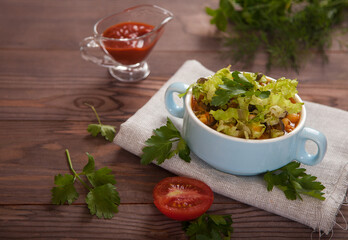 Bean soup with vegetables and segezha greens, tomatoes, sauce on a napkin on a wooden table. Italian Cuisine. Vegetarian food.