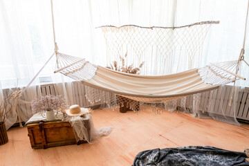 The light photo studio with hammock and big window in beige tones