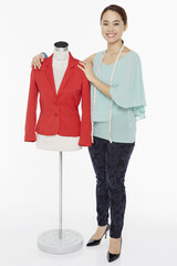 Woman smiling and standing beside a mannequin