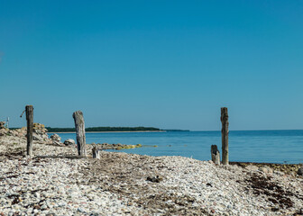 landscape with rocky sea shore and old wooden piles, Baltic sea shore, Saaremaa, Sorves peninsula, Estonia