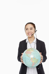 Fototapeta premium Businesswoman with headset holding a globe