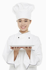 Female chef holding up a tray