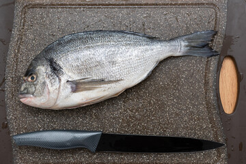 Sea Dorado Fish on cutting board. Ready to cook raw bream fish