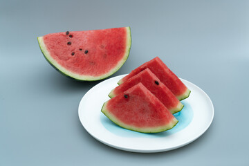 Several pieces of watermelon are placed in a white porcelain dish. Watermelon is placed in a white dish