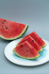 Several pieces of watermelon are placed in a white porcelain dish. Watermelon is placed in a white dish