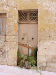 Fototapeta na wymiar Vertical photo of closed shabby front door to abandoned house or production warehouse