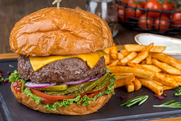 Burger with a big cutlet and vegetables with french fries