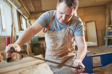 The carpenter debarking the wood with the pull knife