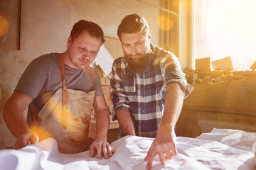 Carpenters discuss the order with the construction plan