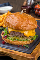 Burger with a big cutlet and vegetables with french fries