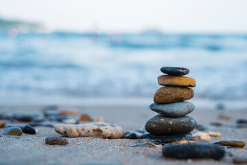 Pebbles are piled on a volcanic rock by the sea. Zen concept. Copy space