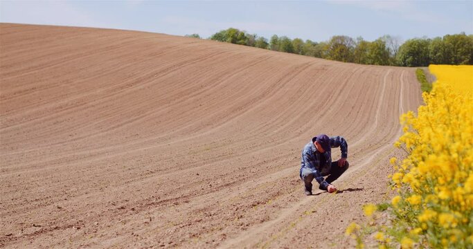 Farmer Examining Soild Dirt in Hands at Dusk