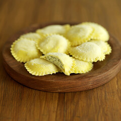 Fresh tortellini pasta on wooden board