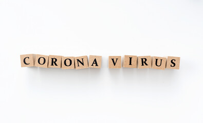 A wooden block with the word coronavirus written on it on a white background