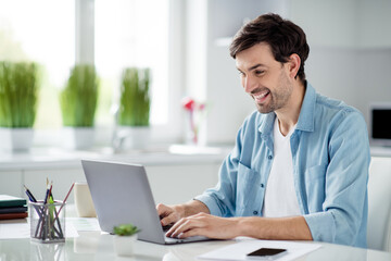 Fototapeta premium Photo of handsome guy student businessman browsing laptop notebook sitting table desktop video call teacher working house online lesson conference social distance quarantine indoors