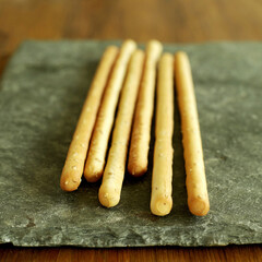 Italian sesame breadsticks on slate