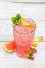 Grapefruit lemonade with ice in a glass cup