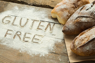 Gluten free word written on a flour with homemade bread. Concept of special diet for people with allergy. - Powered by Adobe