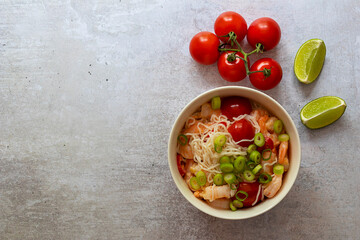 Shirataki Noodles with shrimps, tomatoes, and green onions close-up. Ketogenic, gluten-free diets or lose weight concept. Copy space for text.