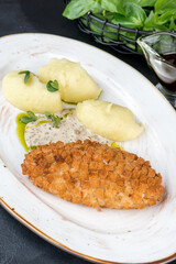 Pozharsky cutlet with potatoes and sauce on a white plate