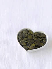 Pumpkin seeds in a heart-shaped bowl