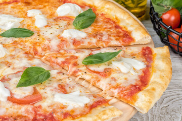 Margarita pizza with sliced slice on a wooden board