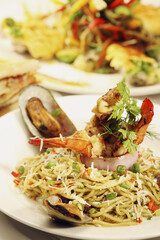 Seafood pasta and other main courses in the background
