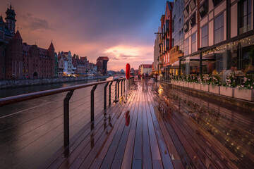 Old town in Gdansk with historical port crane over Motlawa river at rainy sunset, Poland.