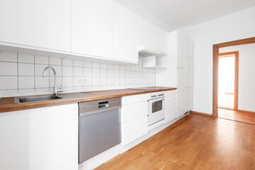 empty,  white kitchen or kitchenette with parquetfloor and wooden tabletop
