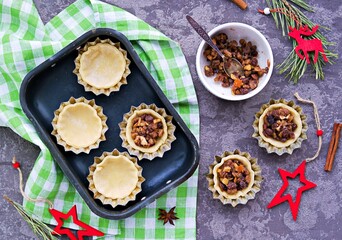 Obraz na płótnie Canvas Step-by-step cooking of mince pies traditional British Christmas shortcrust pastry cakes stuffed with dried fruits, nuts and apples.
